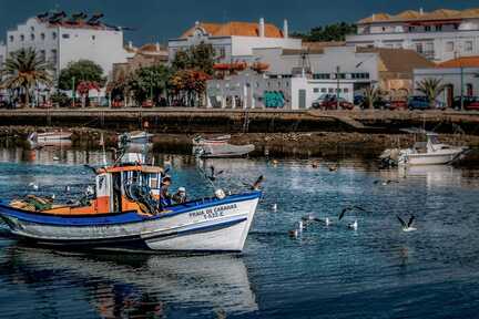 Tavira: Kleinvenedig mit einem Motorboot an der Promenade