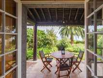 Casa do Monte auf Sao Miguel, einladende überdachte Terrasse mit gemütlicher Sitzgruppe und mediterranem Garten – perfekter Ort zum Entspannen und Genießen.