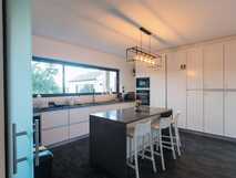 Volcanic Charming House auf Sao Miguel, moderne und helle Küche mit stilvoller Ausstattung und gemütlichem Essbereich.