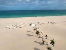 Voi Praia de Chaves Resort auf Boa Vista, endloser weißer Sandstrand mit türkisblauem Meer und schattenspendenden Sonnenschirmen