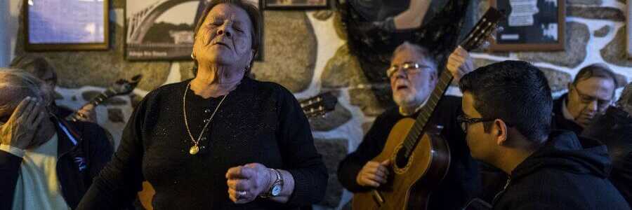 Man sieht eine Fado-Sängerin und Musiker