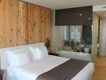 Hotel Pedras do Mar auf Sao Miguel, modernes Zimmer mit Holzakzenten und gemütlichem Doppelbett – ideal für erholsame Nächte bei picotours.