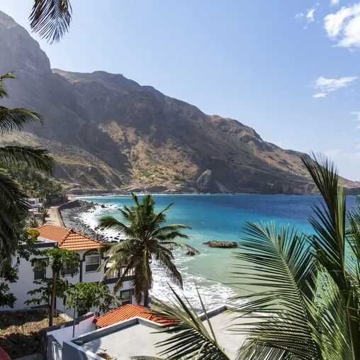 Küstenort Fajã de Água auf der Insel Brava mit bunten Häusern, Palmen und Blick auf das türkisfarbene Meer.