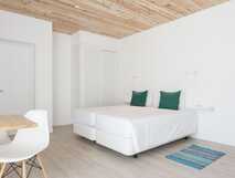 Moderne, helle Ferienwohnung mit gemütlichem Doppelbett und stilvollem Holzdesign – perfekt für Ihren erholsamen Urlaub mit picotours.