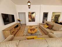 Mil e Uma Noites – Modernes, gemütliches Wohnzimmer mit natürlichem Holzdesign.