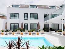 Das Designhotel Pero de Teive Bay auf den Azoren mit Pool, Sonnenliegen und modern-weißer Fassade