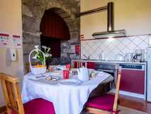 Tradicampo - Casa da Fonte auf Sao Miguel, gemütliche Landhausküche mit rustikalem Flair und einladendem Frühstückstisch für entspannte Urlaubsmomente.