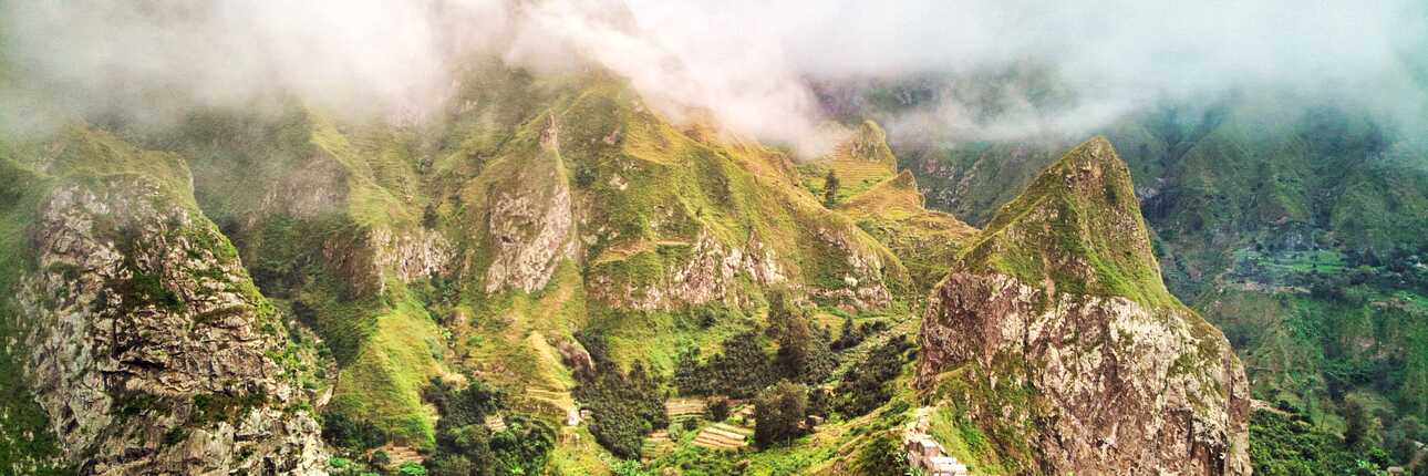 Panoramablick über das grüne Paúl-Tal (Vale do Paúl) auf Santo Antão mit steilen Berggipfeln, Terrassenfeldern und Nebelschwaden auf den Kapverden.