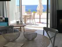 Modernes Apartment im Aparthotel Vinhas do Calhau mit Wohnbereich, Esstisch und Terrasse mit Meerblick auf Pico