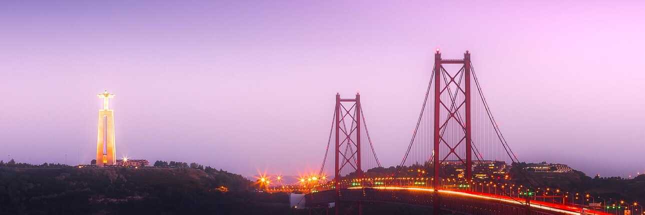 Blick aus der Ferne auf die Brücke und Lissabon im Abendrot