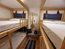 Mil e Uma Noites – Gemütliches Zimmer mit zwei Holzbetagenbetten in maritimem Stil.