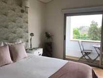 Casa da Cisaltina auf Sao Miguel, gemütliches Zimmer mit modernem Ambiente und Balkon mit grünem Ausblick – ideal für erholsame Urlaubstage.