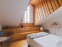 Casa da Cascata auf Sao Miguel, gemütliches Zimmer mit modernem Holzdesign und viel Tageslicht für erholsame Urlaubsmomente.