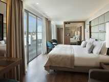 Helles Hotelzimmer mit Doppelbett, Balkon und Blick auf Funchal
