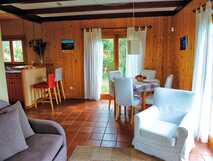 Quinta dos Curubas auf Sao Miguel, gemütliches und helles Wohn- und Esszimmer mit Holzwänden und Zugang zum Garten, ideal für entspannte Urlaubstage.