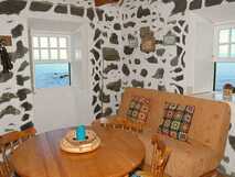 Adegas do Pico auf Pico, gemütlicher Aufenthaltsraum mit rustikalem Steinmauer-Design und Meerblick.