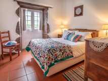 Aldeia da Cuada auf der Insel Flores – Gemütliches, traditionell eingerichtetes Schlafzimmer mit liebevollen Details und gemütlicher Atmosphäre.