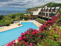 Caloura Hotel Resort - Poolanlage mit Liegen und Sonnenschirmen - Meerblick inklusive