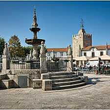 Brunnenplatz mit alter Kirche und Marktständen in Ponte de Lima, ein Wanderer passiert das Zentrum.