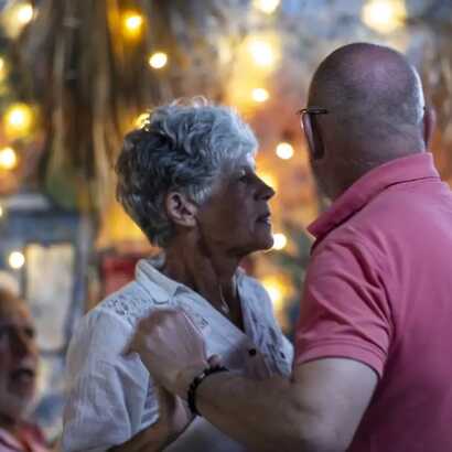 Älteres Paar tanzt gemeinsam unter Lichterketten bei einem festlichen Abend in São Filipe