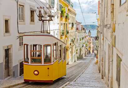Die berühmte gelbe Straßenbahn fährt durch die Gassen von Lissabon. Die Fahrt gehört zu den Portugal Highlights einer jeden Reise nach Lissabon.