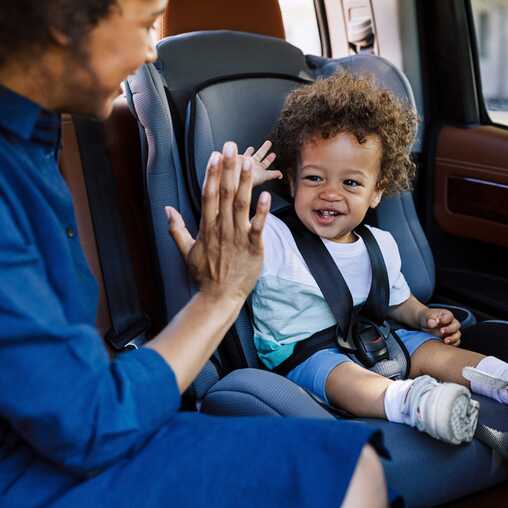 Eine Mutter fährt mit ihrem Kleinkind im Kindersitz – sicheres Reisen auf den Kapverden.