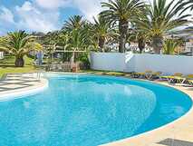 Erfrischender Pool mit Palmen und Liegen – Ihr entspannter Urlaub mit picotours!