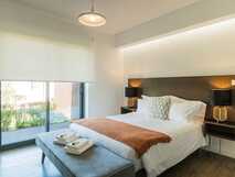 Modern eingerichtetes Schlafzimmer mit Kingsize-Bett und direktem Zugang zur Terrasse.
