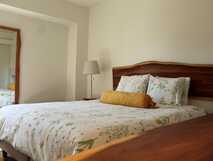 Casa da Cisaltina auf Sao Miguel, gemütliches und stilvolles Schlafzimmer mit natürlicher Holzdekoration und floralem Bettbezug, ideal für erholsame Nächte.