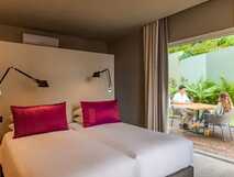 Quinta da Abelheira auf Sao Miguel, modernes Zimmer mit gemütlichen Betten und privater Terrasse für entspannte Urlaubsmomente.