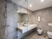 Aqua Populo Eco Village auf Sao Miguel, modernes und stilvolles Badezimmer mit geräumiger Dusche und elegantem Design, ideal für nachhaltigen Komfort bei picotours.