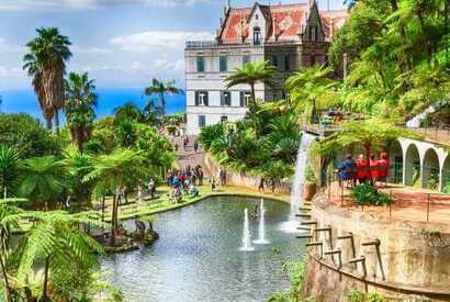 Blick auf den Monte Palace Tropical Garden mit exotischer Vegetation, fernöstlichen Skulpturen und Wasserbecken auf Madeira