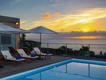 Mosteiros Place auf Sao Miguel, luxuriöse Poolterrasse mit Sonnenliegen und atemberaubendem Meerblick bei Sonnenuntergang – perfekte Entspannung mit picotours.