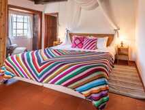 Aldeia da Cuada auf Flores – Gemütliches, bunt dekoriertes Schlafzimmer mit traditionellem Charme.