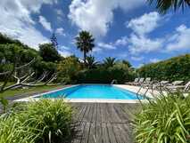Quinta dos Bravos auf Sao Miguel, einladender Außenpool inmitten tropischer Gartenlandschaft unter blauem Himmel – perfekt zum Entspannen mit picotours.