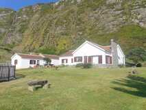Casa da Cascata auf Flores, idyllisches Landhaus vor beeindruckender Bergkulisse mit Wasserfällen.