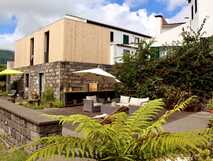 Casa da Cisaltina auf Sao Miguel, charmantes Hotel mit moderner, rustikaler Architektur und gemütlicher, grüner Außenterrasse ideal zum Entspannen.