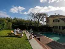 Casa Portuguesa Boutique Hotel auf Sao Miguel, entspannter Außenbereich mit Pool und Liegestühlen in idyllischer Gartenanlage, perfekt für einen erholsamen Inselurlaub.