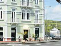 International Azores Boutique Hotel auf Faial, charmante Hotelfront mit gemütlicher Außenterrasse und maritimer Atmosphäre am Hafen.