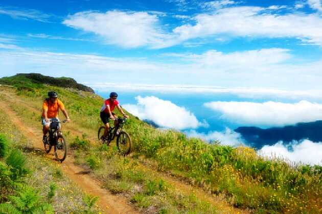 zwei Radfahrer fahren Rad hoch über den Wolken auf Madeira