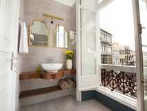 Casa das Palmeiras auf Sao Miguel – stilvolles Badezimmer mit offenem Fenster und Blick auf historische Stadtarchitektur, ideal für erholsame Momente.