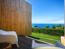 Mosteiros Place Sao Miguel, entspannte Terrasse mit Meerblick und moderner Holzarchitektur – perfekt für einen erholsamen Urlaub mit PicoTours.