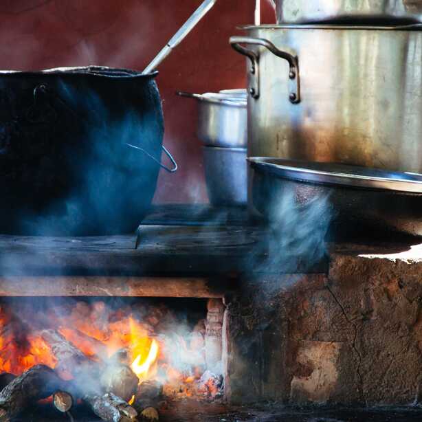 Traditionelles Essen auf den Azoren: Kochtöpfe auf einer Herdplatte über offenem Holzfeuer.