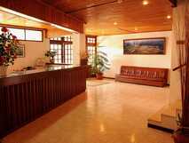 Hotel Ocidential auf Flores – Freundlicher Empfangsbereich mit warmem Ambiente und stilvollem Holzmobiliar.