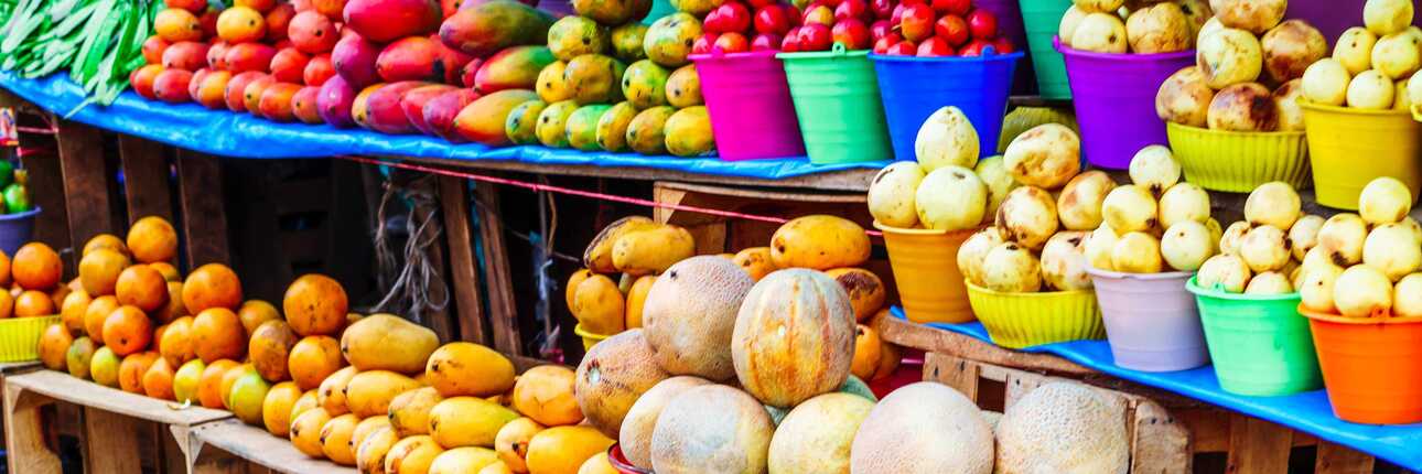 Bunter Obststand auf einem Markt der Kapverden mit exotischen Früchten in Körben.