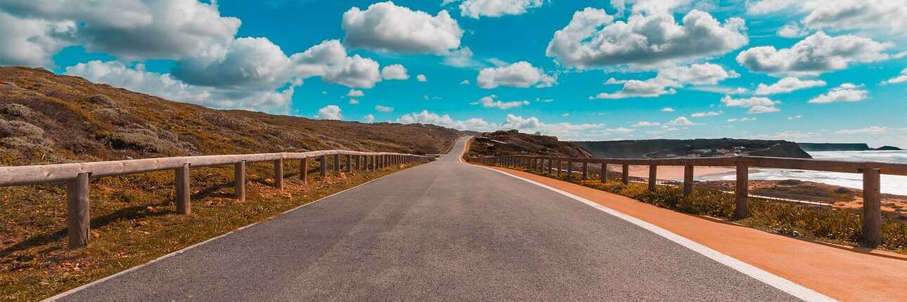 Küstenstraße in Portugal mit Mietwagenroute entlang des Atlantiks, weitem Blick auf die Landschaft und Zugang zu den Stränden – ideal für eine individuelle Rundreise.