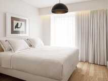 Casa da Galeria auf Sao Miguel – modernes, helles Schlafzimmer mit komfortablem Doppelbett und eleganter Ausstattung