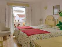 Helles Doppelzimmer mit getrennten Betten und Balkon im historischen Hotel Casa do Adro