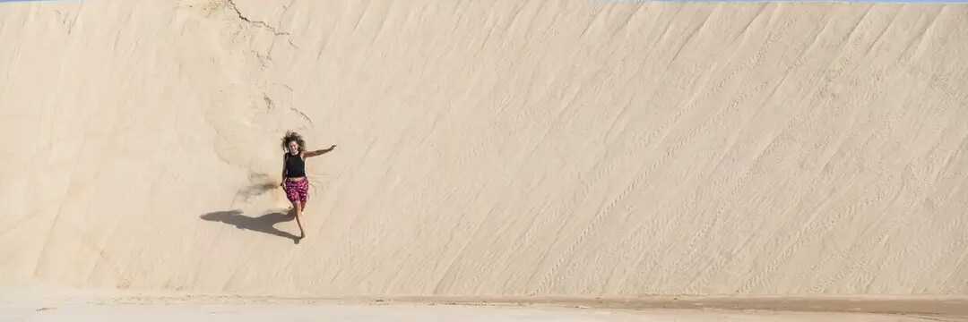 Eine einzelne Person spaziert am endlosen Sandstrand der Praia de Santa Monica auf Boa Vista, Kapverden.