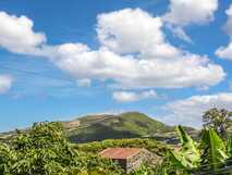Quinta dos Frutos auf Flores – idyllischer Ausblick auf grüne Hügel und blauen Himmel.